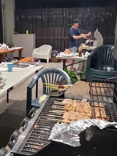 夜晚實際烤肉情景，串烤與香腸在烤爐上滋滋作響