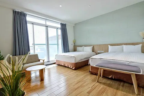 Twin-bed quad room with a round rattan mirror and wood shelving, with its own large terrace and pool
