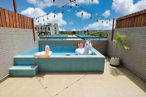 Twin-bed quad room with a round rattan mirror and wood shelving, with its own large terrace and pool