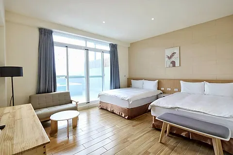 Twin-bed quad room with a round hanging mirror and wood clothes rack, with its own large terrace and pool