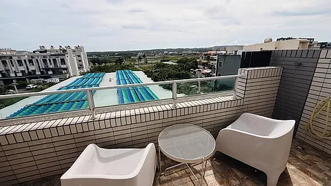 Double room with white bedding, a wood headboard wall, and floor-to-ceiling windows opening onto a private rooftop terrace