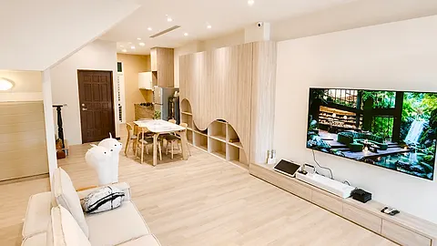 從麻將桌旁的房門望向餐廳與電視牆，木質大門與磁磚地板